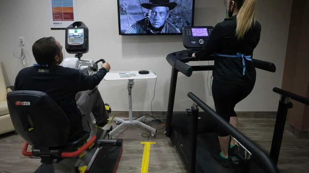Two patients exercise in the telehealth cardio rehab room at Benson Hospital. 